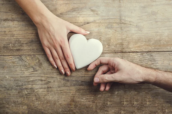 Homem oferecendo um coração branco ternamente a uma mulher — Fotografia de Stock