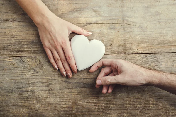 Uomo che offre un cuore bianco teneramente a una donna — Foto Stock