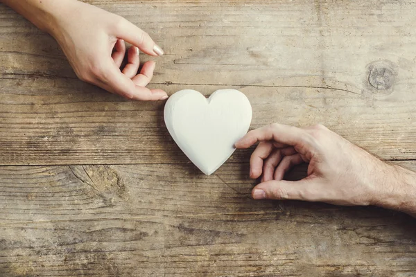 Hands connected through a white heart. — Stock Photo, Image