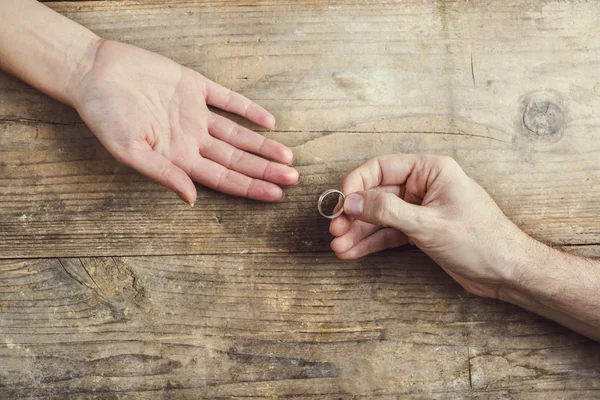 Hombre poniéndose el anillo de compromiso tiernamente a su mujer — Foto de Stock