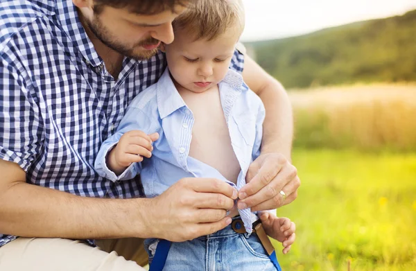 Kleine jongen krijgen gekleed door zijn vader. — Stockfoto