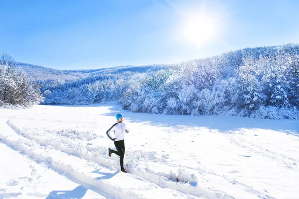 Спортсмен бегает зимой — стоковое фото