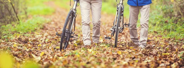 Coppia anziana che cammina con biciclette — Foto Stock