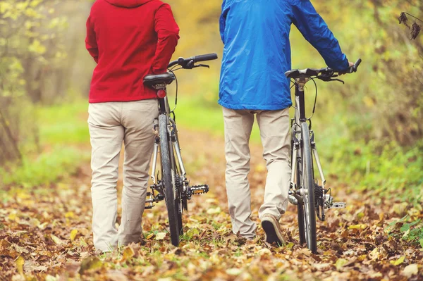 Para starszych o spacer z rowerami — Zdjęcie stockowe