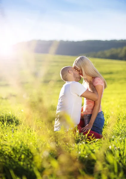 Jovem casal apaixonado no campo ensolarado — Fotografia de Stock