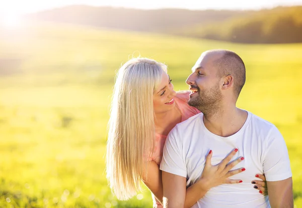 Молода пара закохалася в сонячне поле — стокове фото