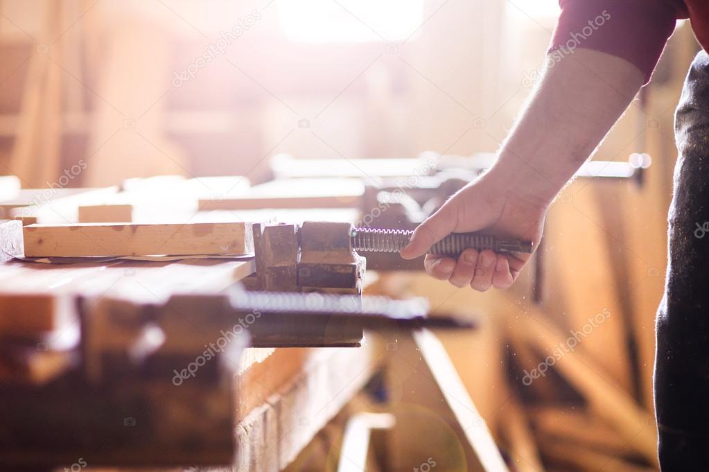 Carpenter screwing a glue clamp