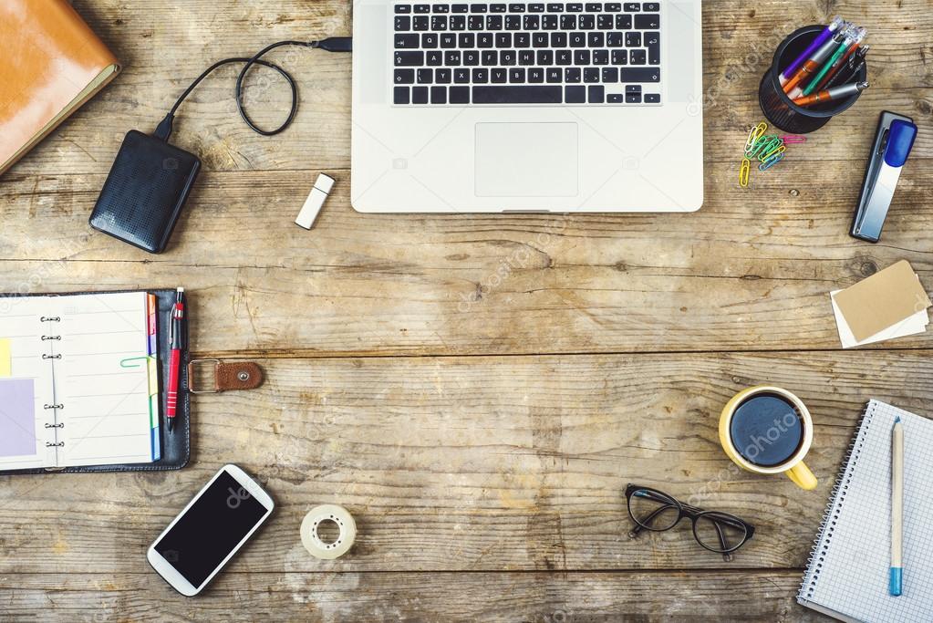 Desk, gadgets and office supplies. Flat lay. Wooden desk. Stock Photo by  halfpoint