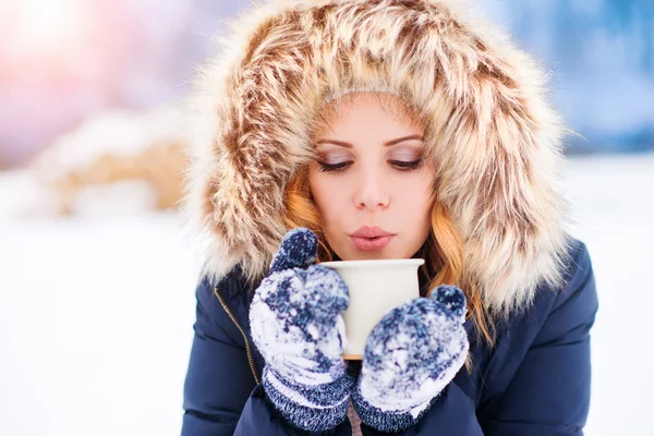 Frau im Schnee mit einer Tasse Kaffee — Stockfoto