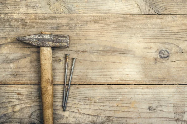 Desk of a carpenter with a hammer and two nails — Stock Photo, Image