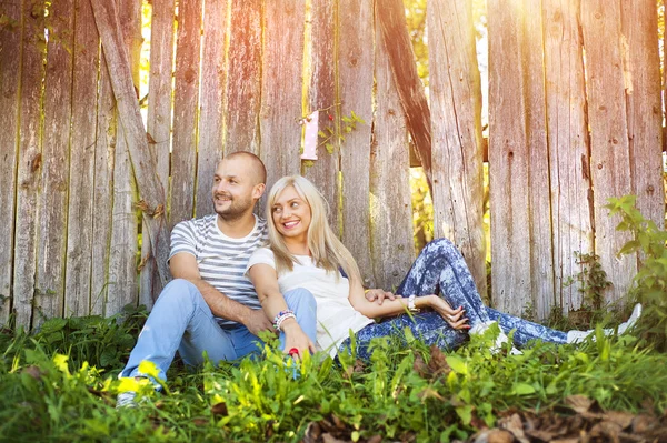 Paar knuffelen en naast het hek liggen — Stockfoto