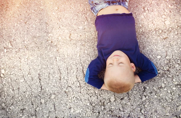 Little boy lying on the ground — Stock Photo, Image