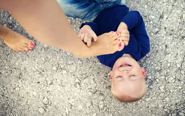 Malý chlapec, hrál s tímto matky nohou — Stock fotografie