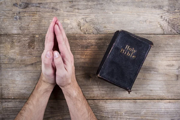 Руки молитися людина з Біблії — стокове фото