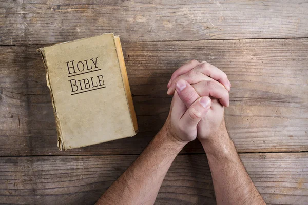 Hands of praying man with Bible — Stock Photo, Image