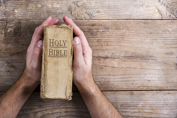 Manos sosteniendo la Biblia — Foto de Stock