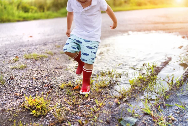 Kleiner Junge spielt in einer Pfütze — Stockfoto