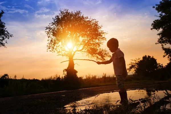 Мальчик играет на закате — стоковое фото