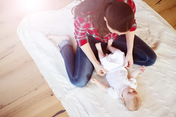 Bebé niña vistiéndose por su madre — Foto de Stock