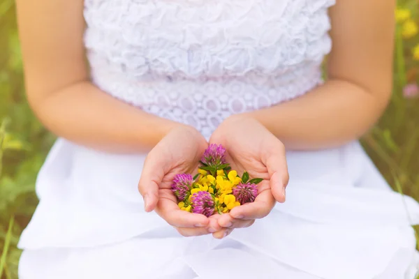 Vrouw met bloemen in haar handen — Stockfoto