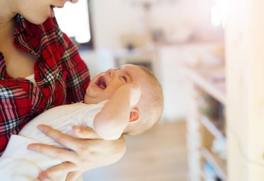 Annesinin kollarında ağlayan bebek