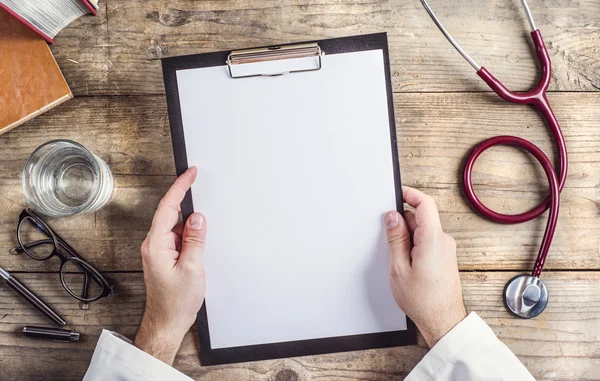 Arzt hält ein leeres Blatt Papier — Stockfoto