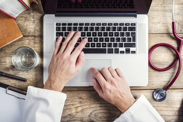 Mãos de médico digitando em um computador — Fotografia de Stock