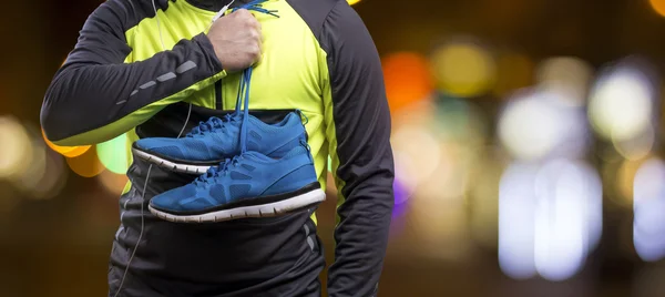 Sportsman holding blue sneakers — Stock Photo, Image