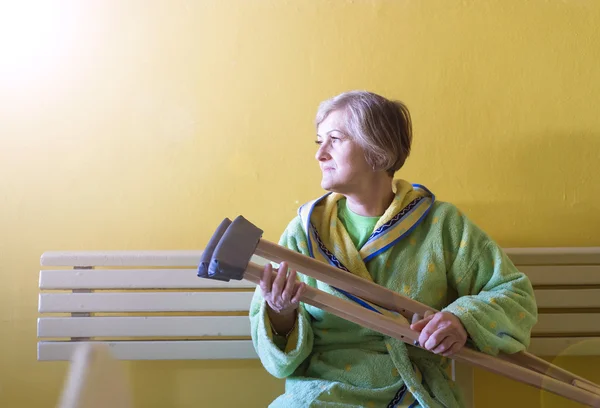 Mujer mayor con muletas — Foto de Stock