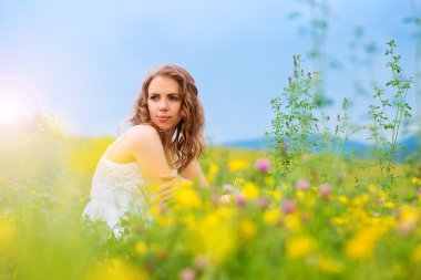 Bir çayır üzerinde oturan kadın.