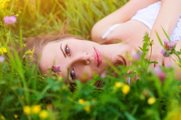 Mujer acostada en un prado lleno de flores . —  Fotos de Stock