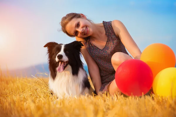 Mujer con globos sosteniendo un perro — Foto de Stock