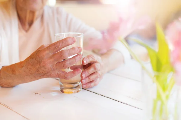 Senior woman holding a glass of water — Stock Photo, Image