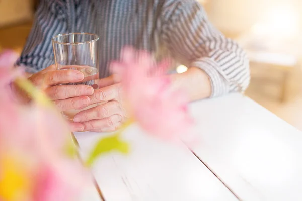 Seniorin hält ein Glas Wasser — Stockfoto