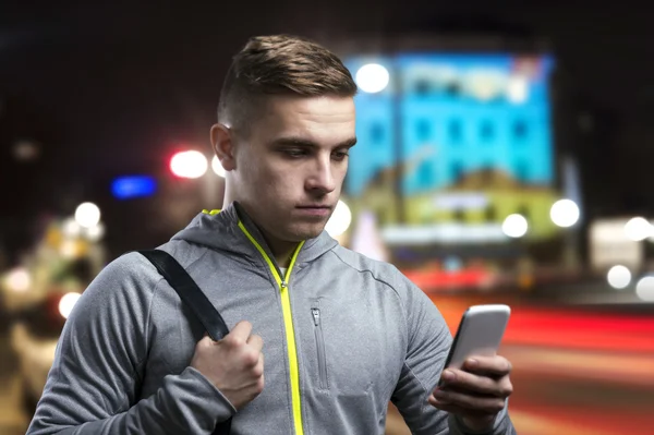 Deportista con teléfono inteligente en la noche —  Fotos de Stock