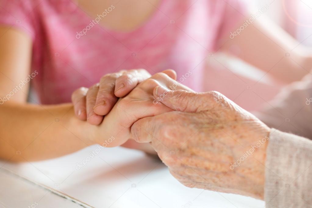 Grandmother and granddaughter holding hands.