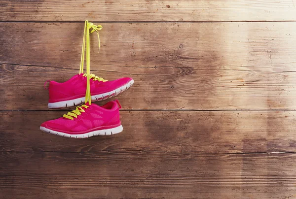 Sneakers hang on wooden fence — Stock Photo, Image