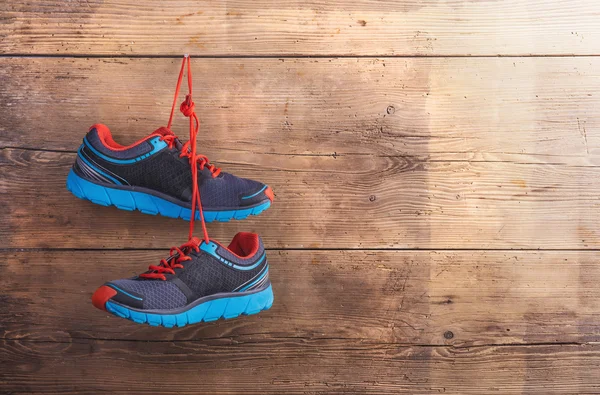 Sneakers hang on wooden fence — Stock Photo, Image