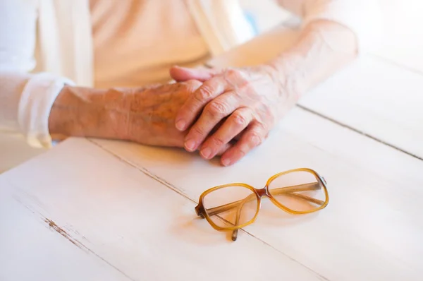 Senior woman holding glasses — Stock Photo, Image