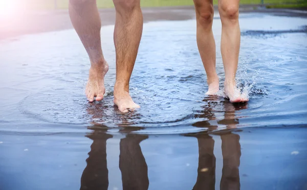 Feet walking in puddle — Stock Photo, Image
