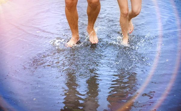 Feet walking in puddle — Stock Photo, Image