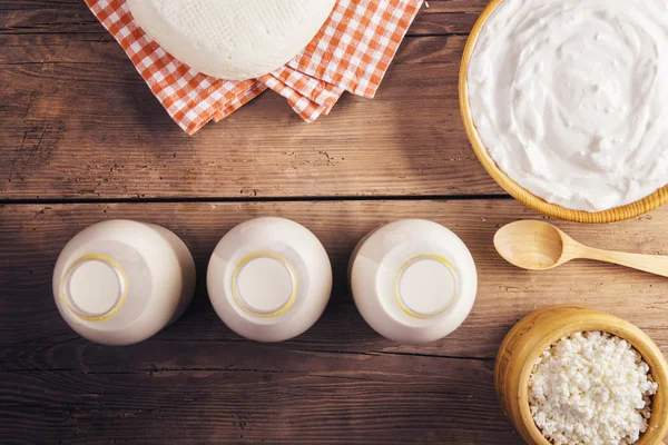 Produtos lácteos em uma mesa de madeira — Fotografia de Stock