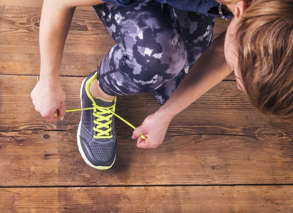 Joven corredora atándose los zapatos — Foto de Stock