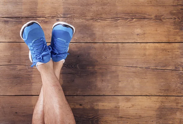 Gambe di un corridore su un pavimento di legno — Foto Stock