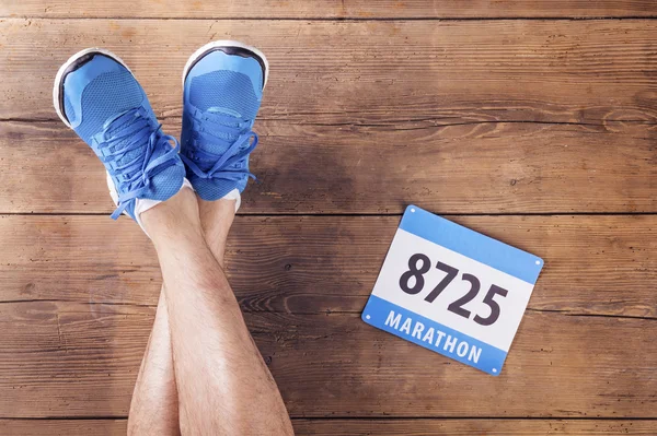 Legs of a runner and race number — Stock Photo, Image