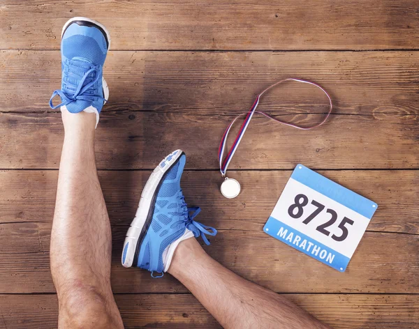 Bir koşucu, madalya ve ırk sayının bacaklar — Stok fotoğraf