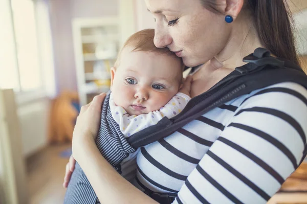 Mother with her daughter in baby carrier — Stock Photo, Image