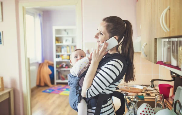 Mother with her baby in a carrier — Stock Photo, Image