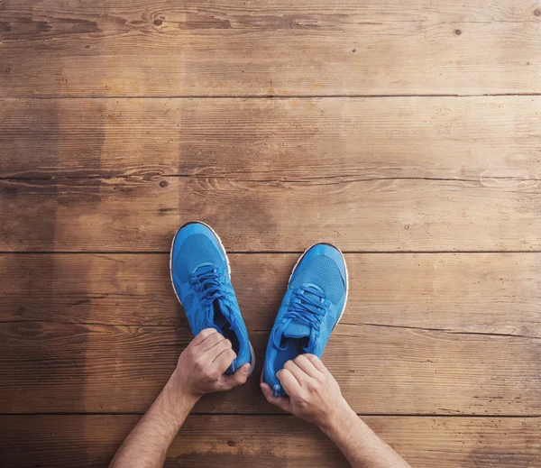 Hombre sosteniendo zapatos de correr —  Fotos de Stock