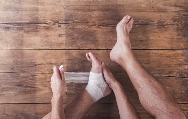 Injured runner sitting on a floor — Stock Photo, Image